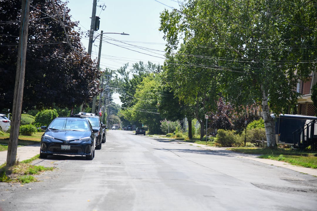Photo of Foster Avenue with cars parked along the side of the road.