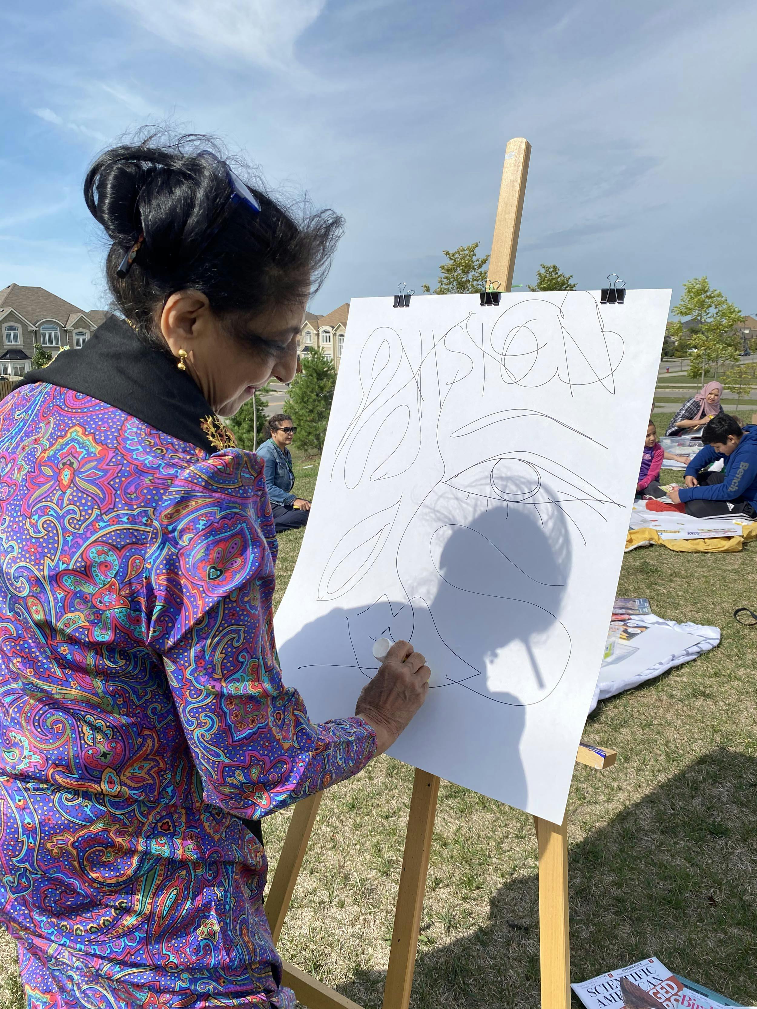 Adult drawing at an easel. 