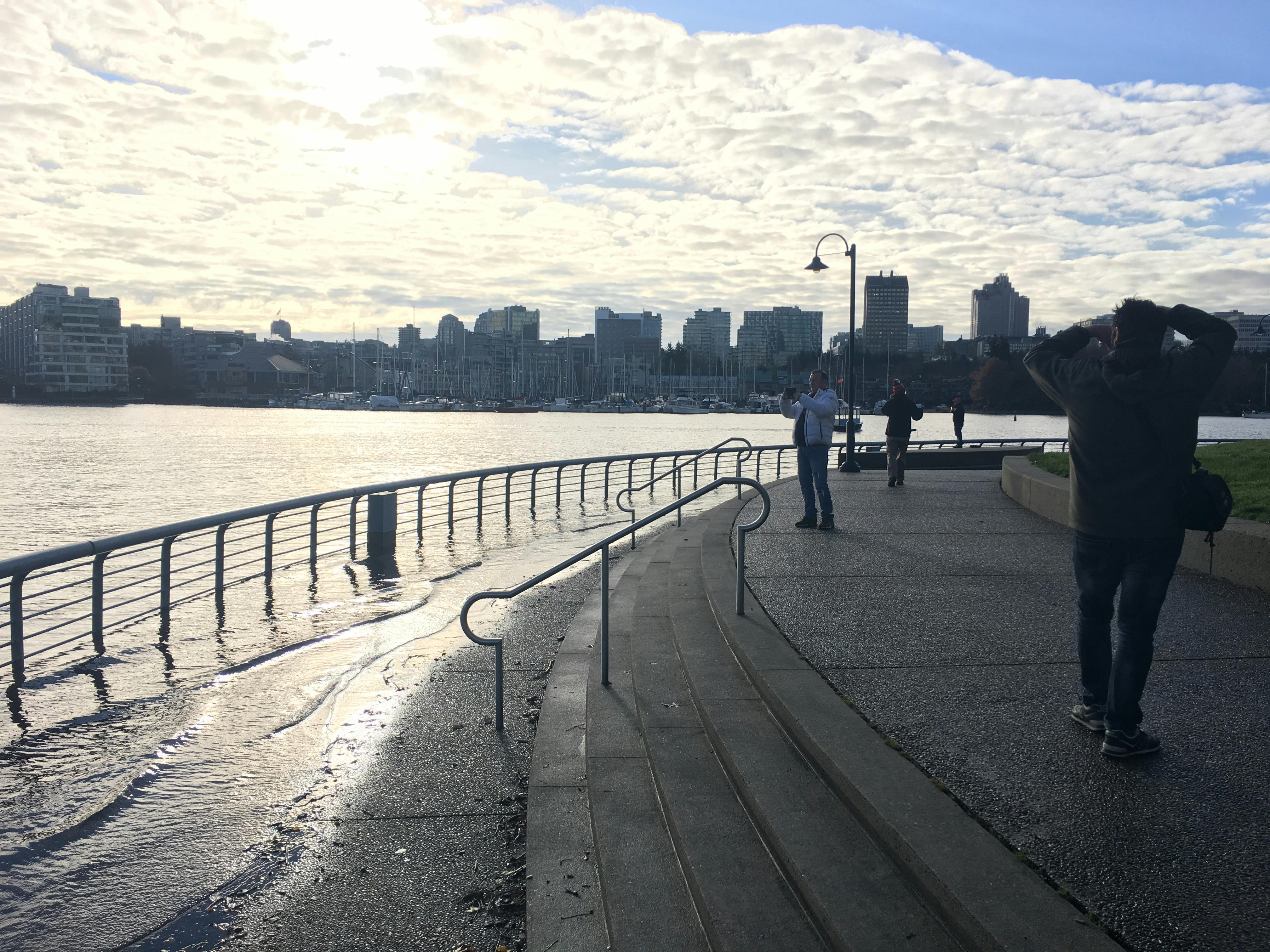 2017 king tide event in Yaletown. The water is lapping over the edge of the walkway and is flooding parts of the seawall.