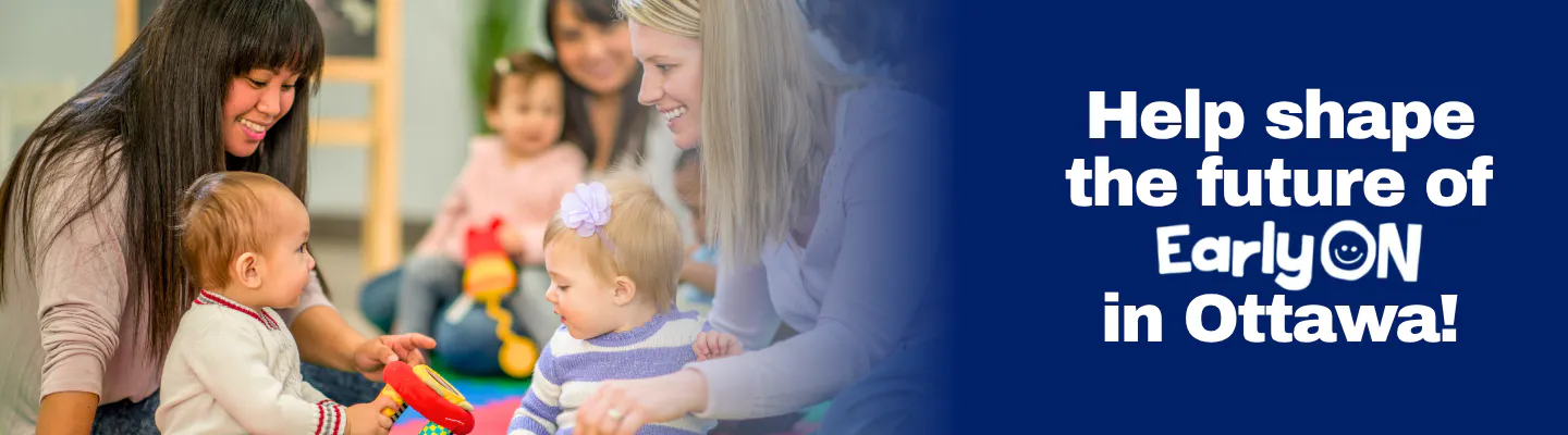 Two parents with their young children playing with a brightly coloured toy; parent and child sitting in the background