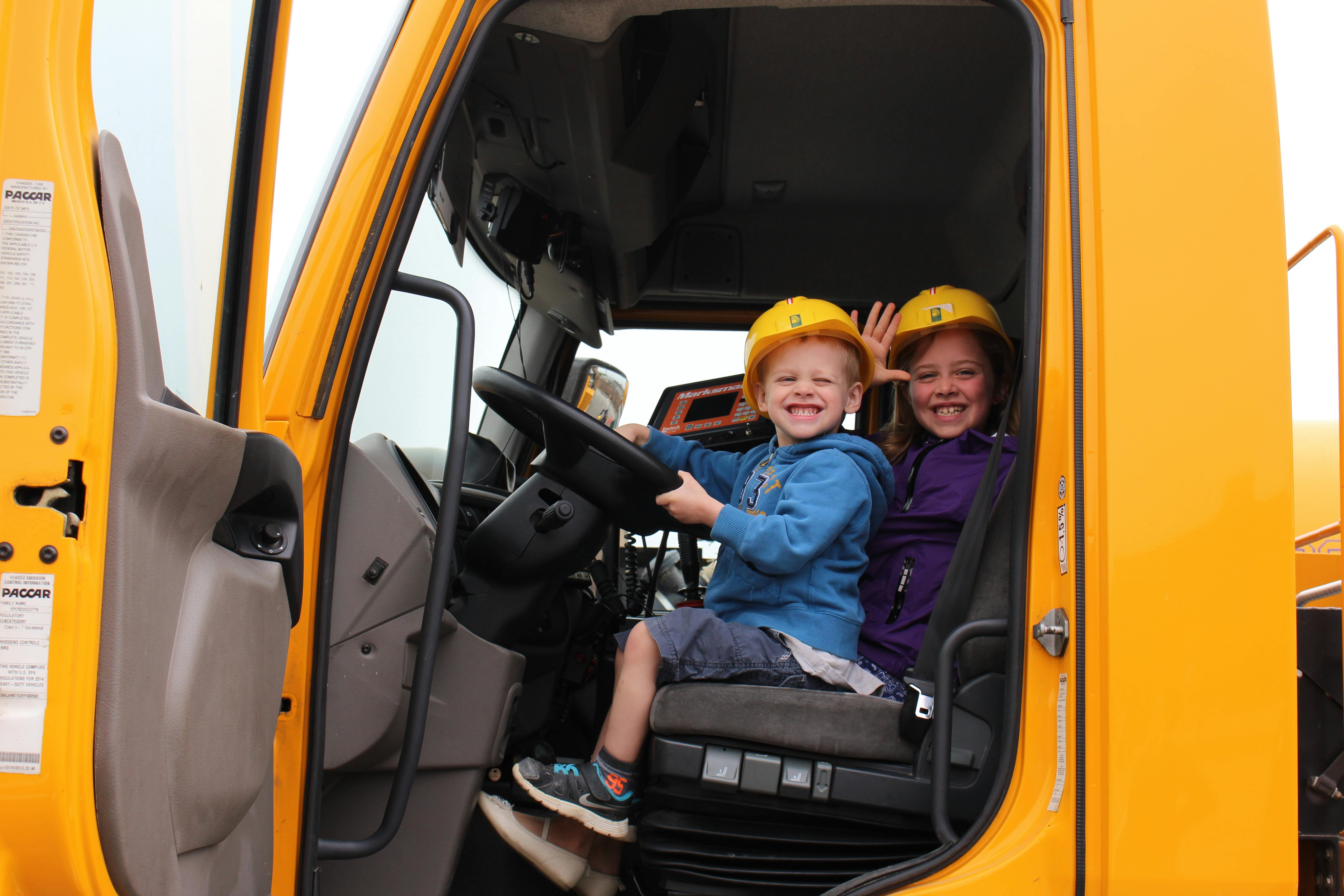 Kids laughing in truck at Doors Open event.