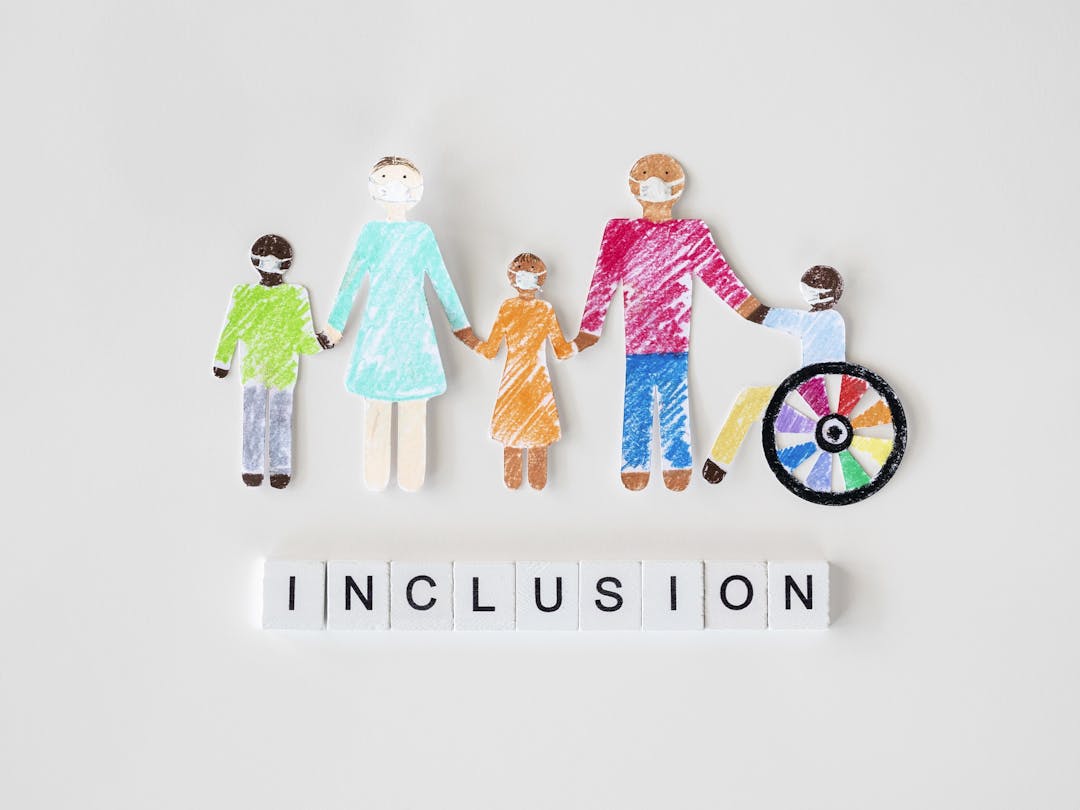 people cut out of paper and coloured with crayons with word 'inclusion' beneath in letter tiles