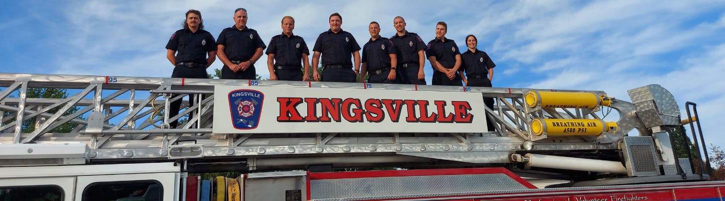 Fire recruits stand on top of Fire Truck