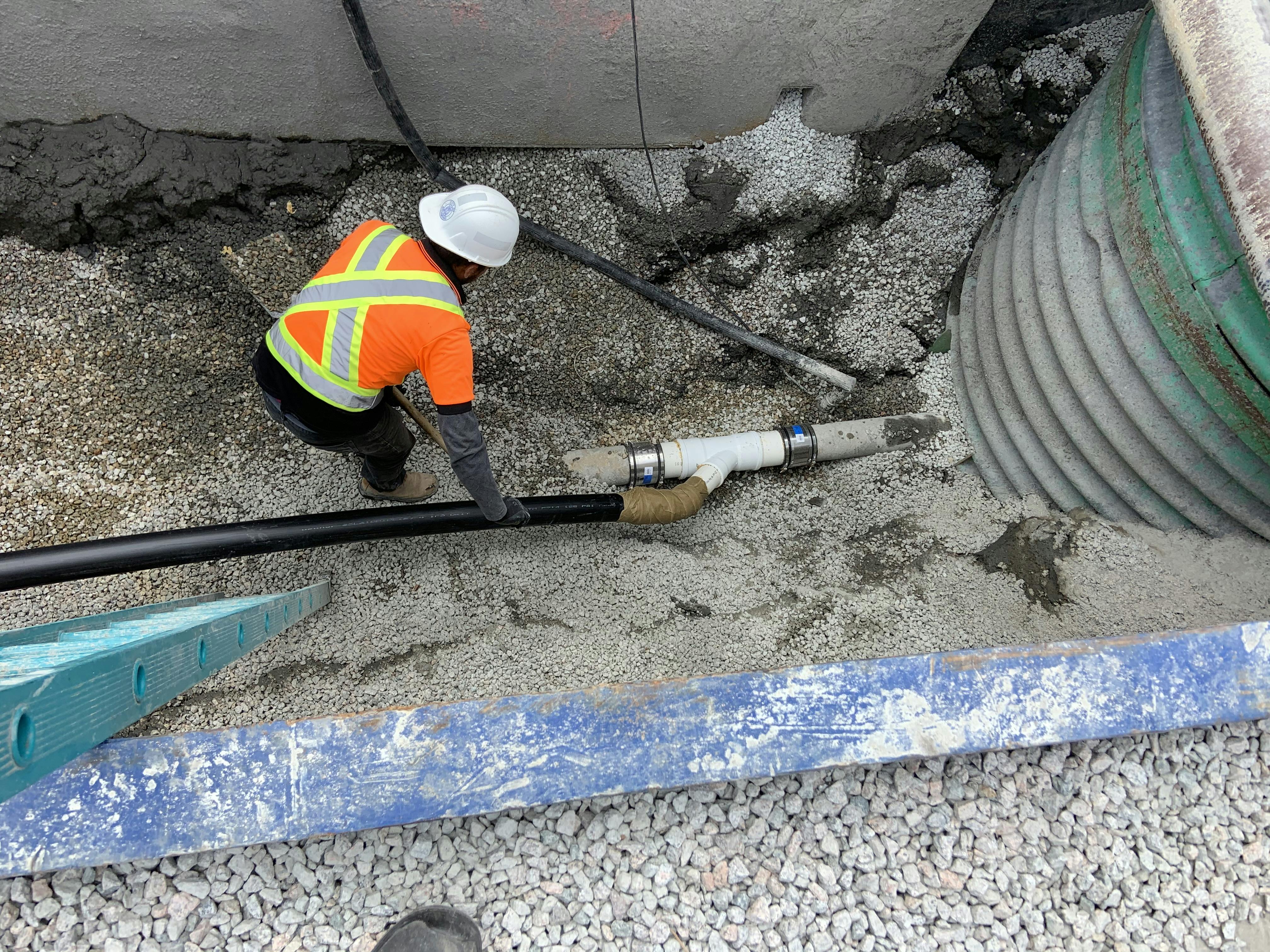 City worker installing a bypass pipe to maintain sanitary service during construction