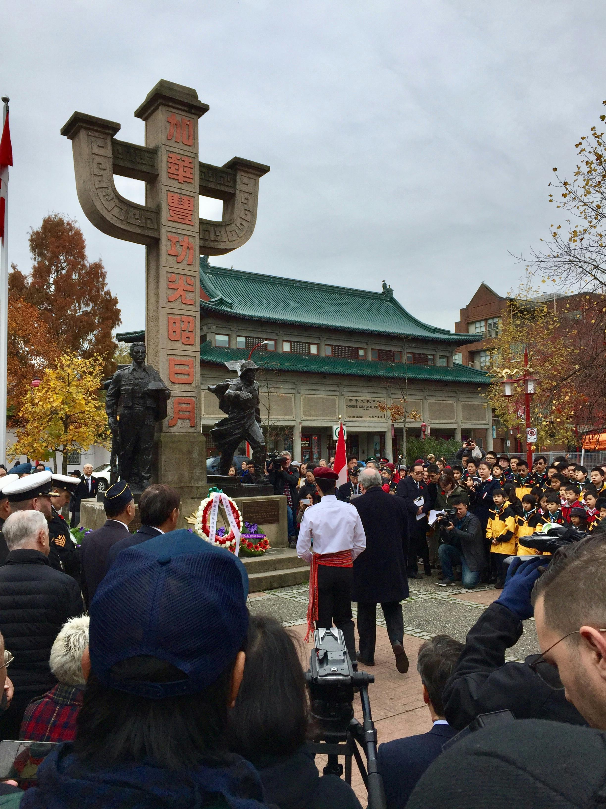 Several people surround the monument in Memorial Plaza, honouring the contributions of Chinese-Canadians to Canada