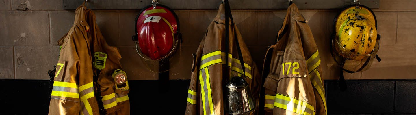 Image of fire suits hanging on hooks