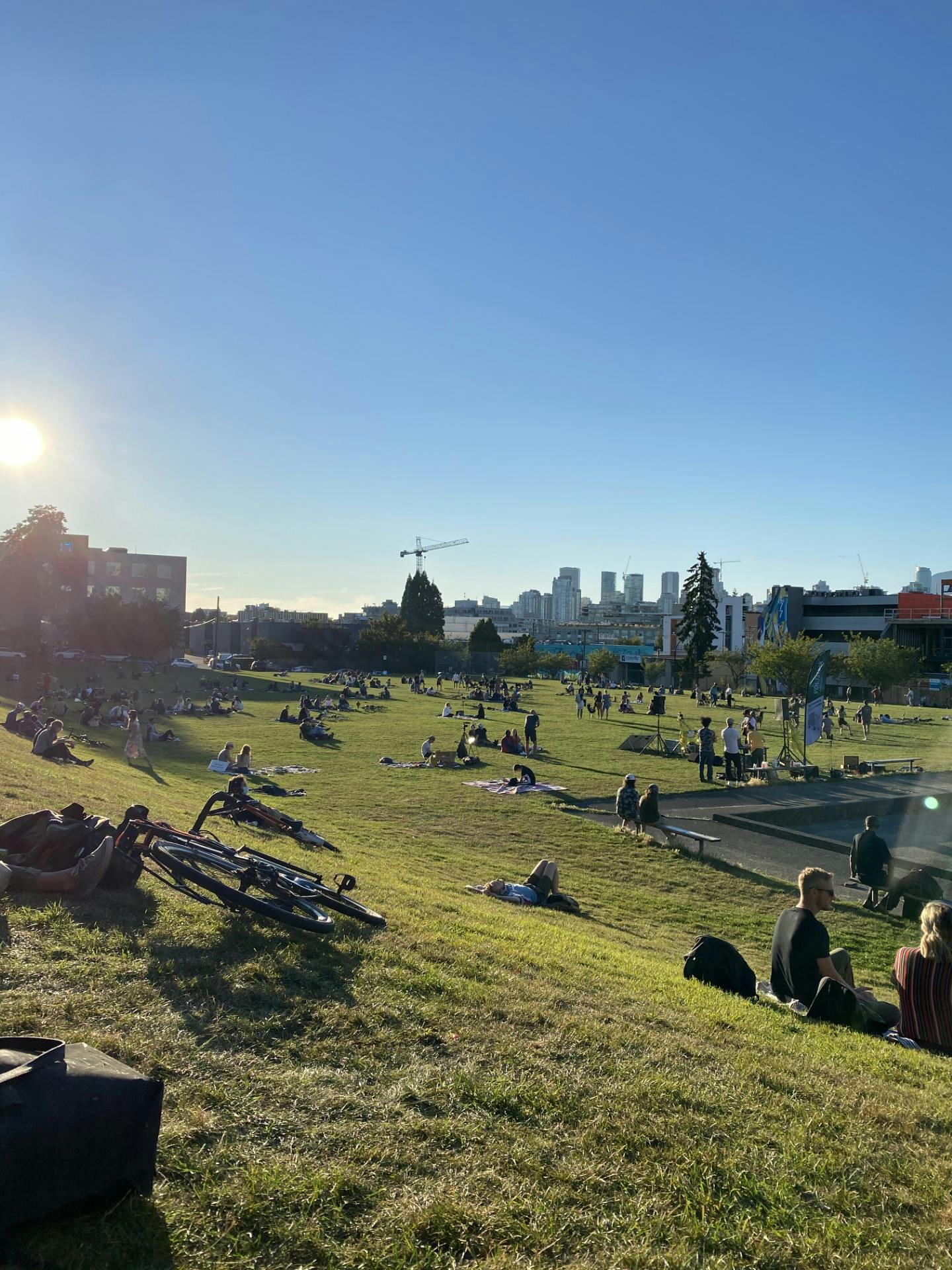 People sitting on the slope and on the field waiting for sunset