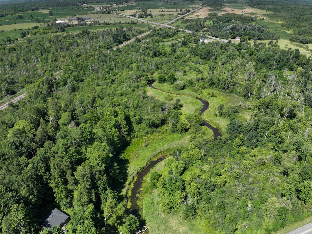 An aerial shot of Bear Brook running through agricultural land.