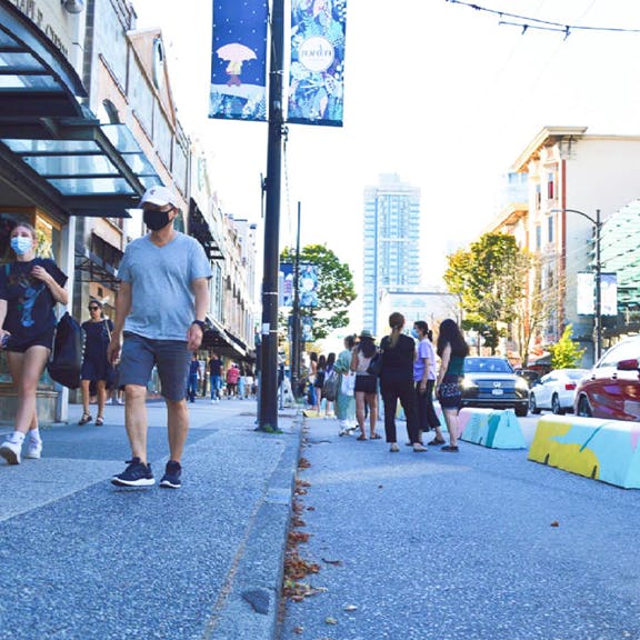 Small groups of people mingling on an expanded sidewalk