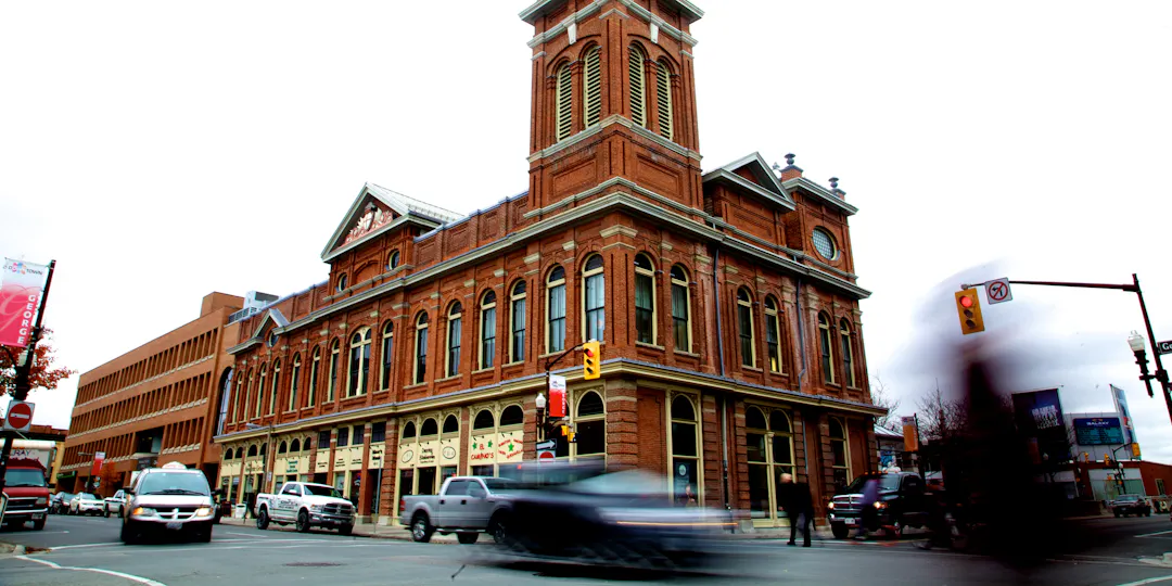 An image of a signalized intersection in an urban setting showing the movement of pedestrians and vehicles 