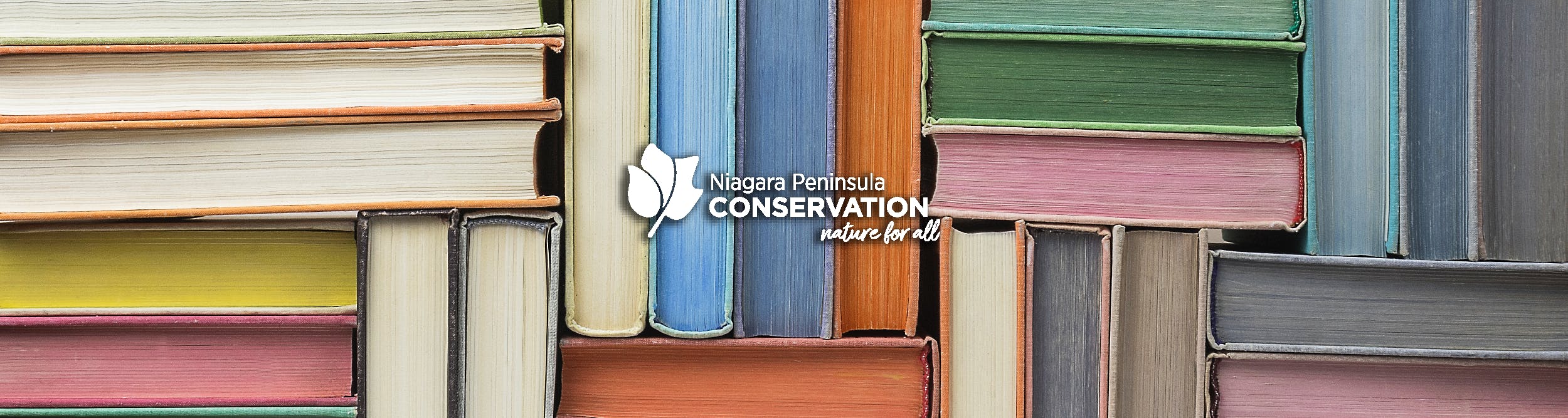 Books placed in nature with NPCA Logo design on right side of image