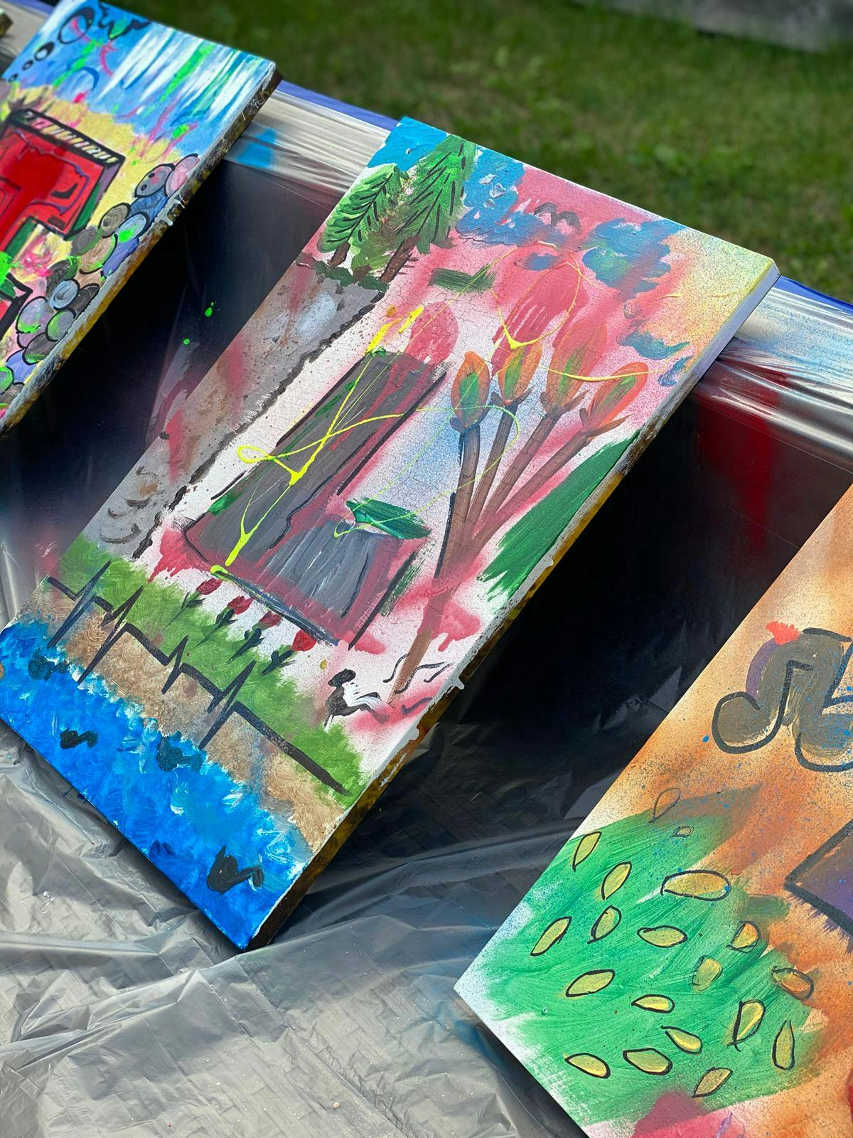 Close-up of canvas featuring the letter "L" with depictions of trees and nature.