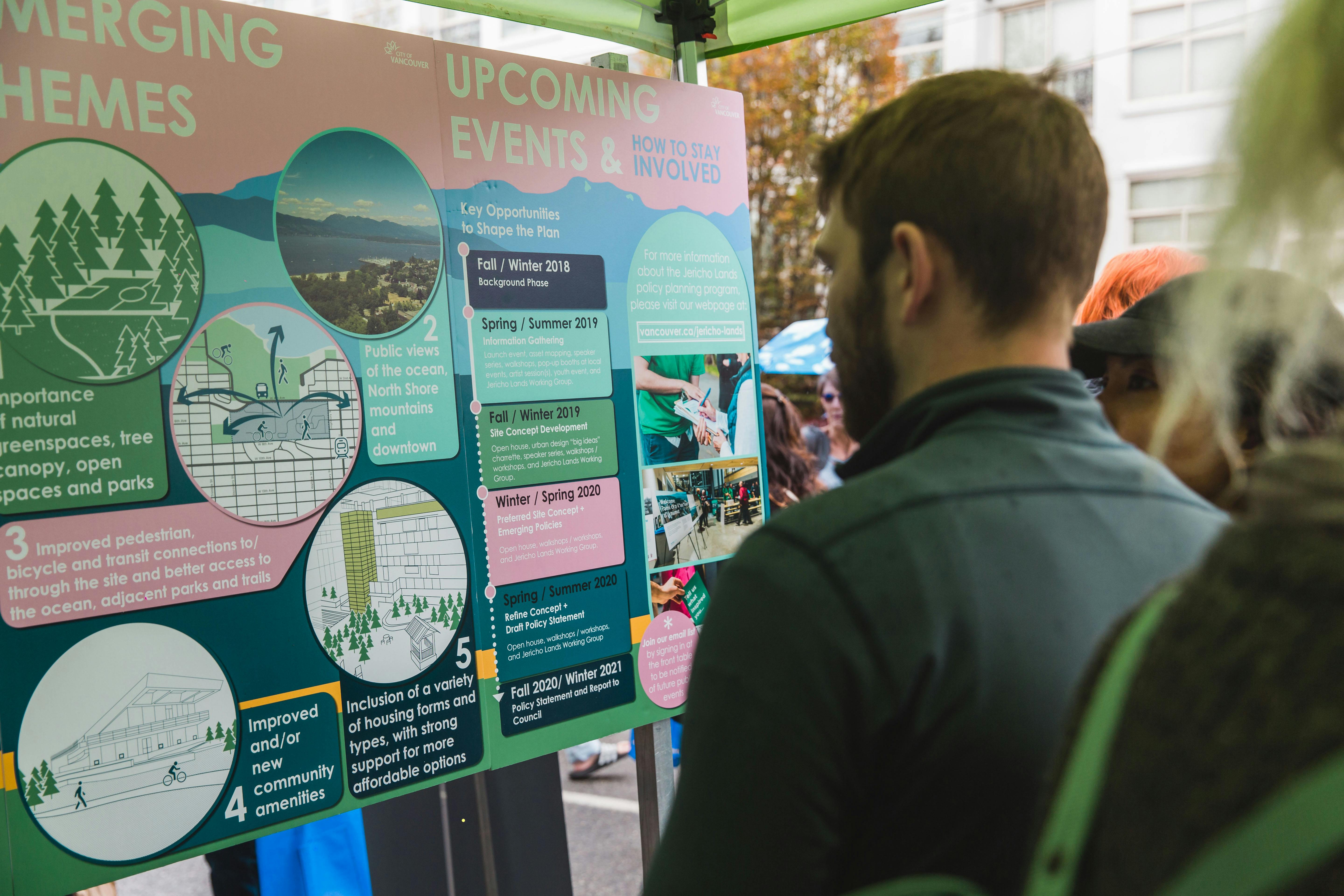 People reading an info board at pop up.