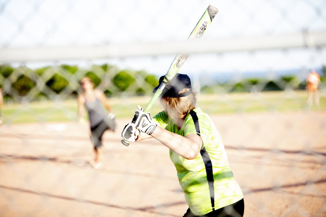 A women swings a baseball bat.