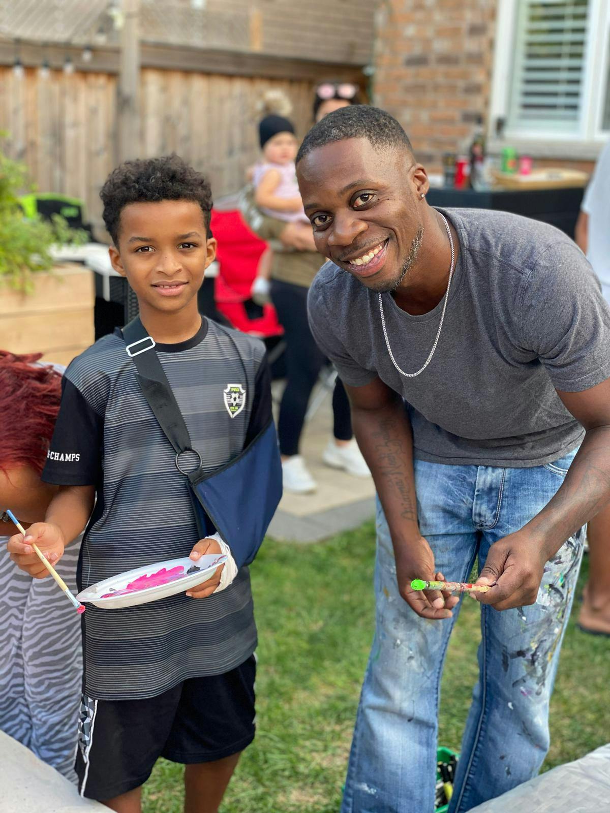 Artist-facilitator Omar (at right) pictured with young participant.