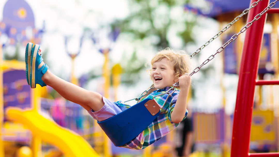 A child balances on play equipment.
