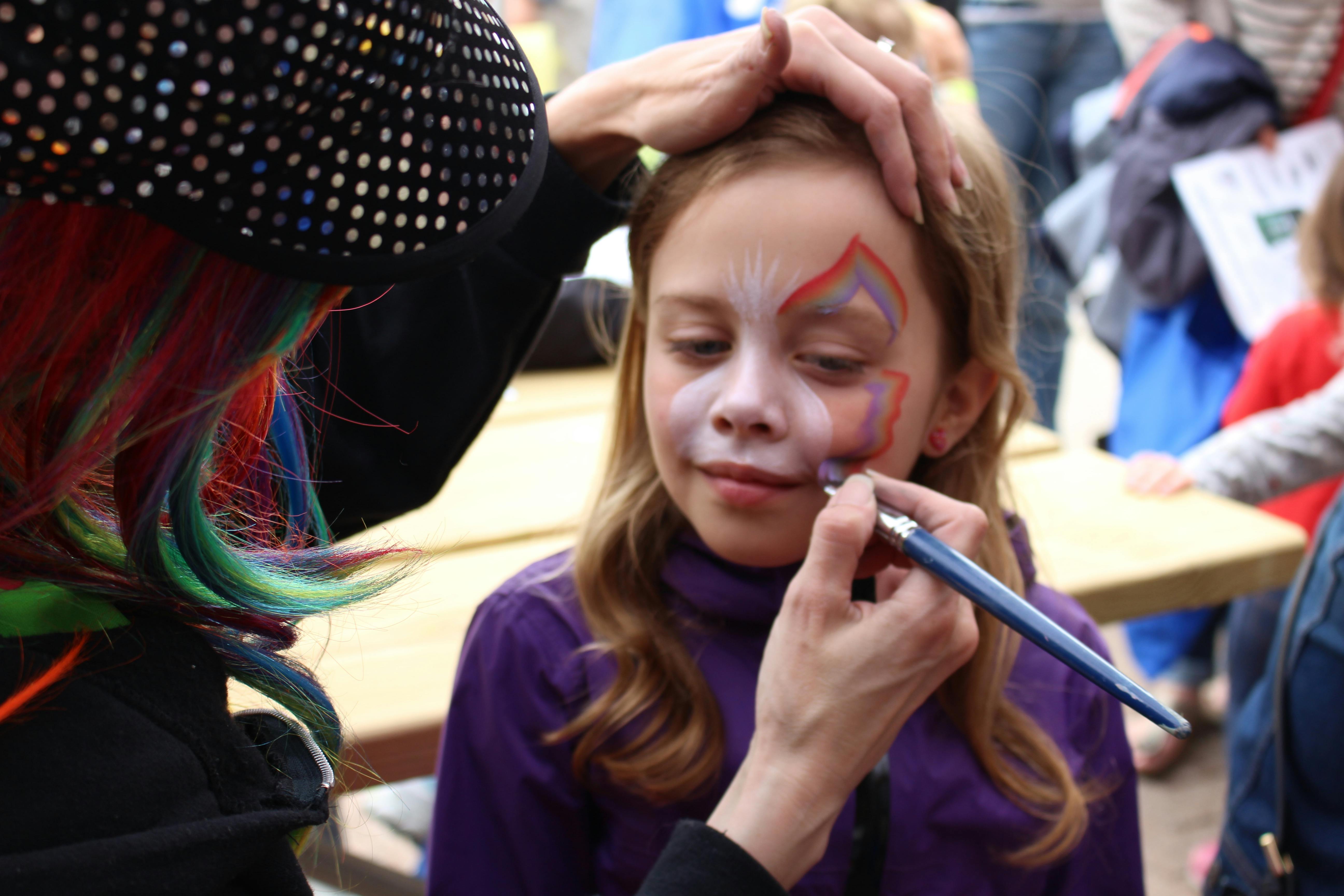 A child having their face painted at Doors Open.