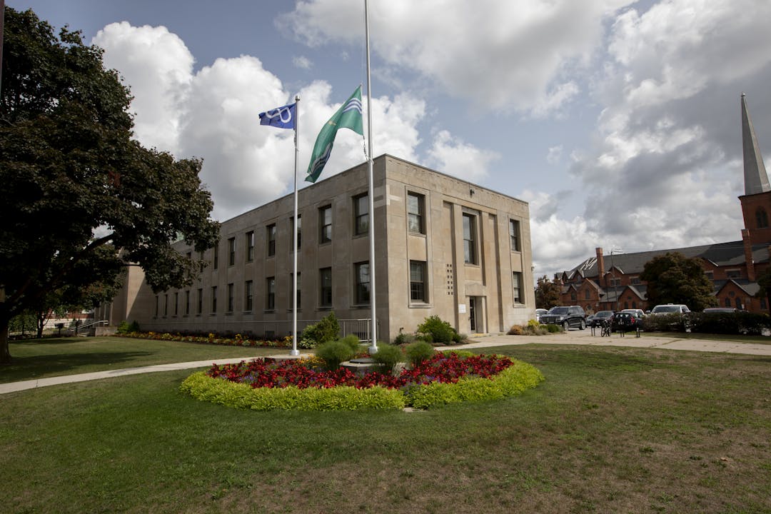The Metis Nation flag and City of Peterborough flag are flying at City Hall on summer day