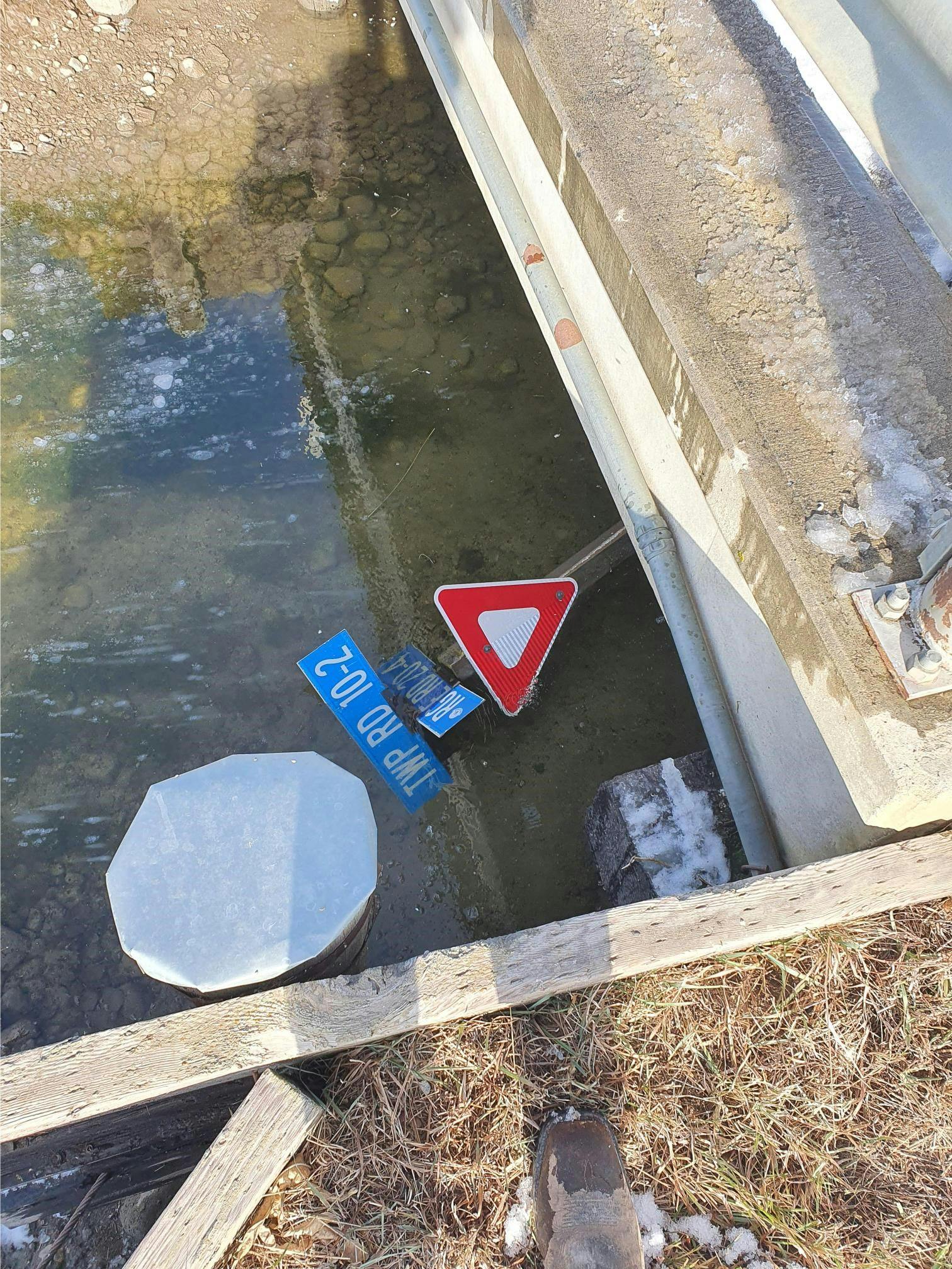 A yield sign was removed and discarded into a canal