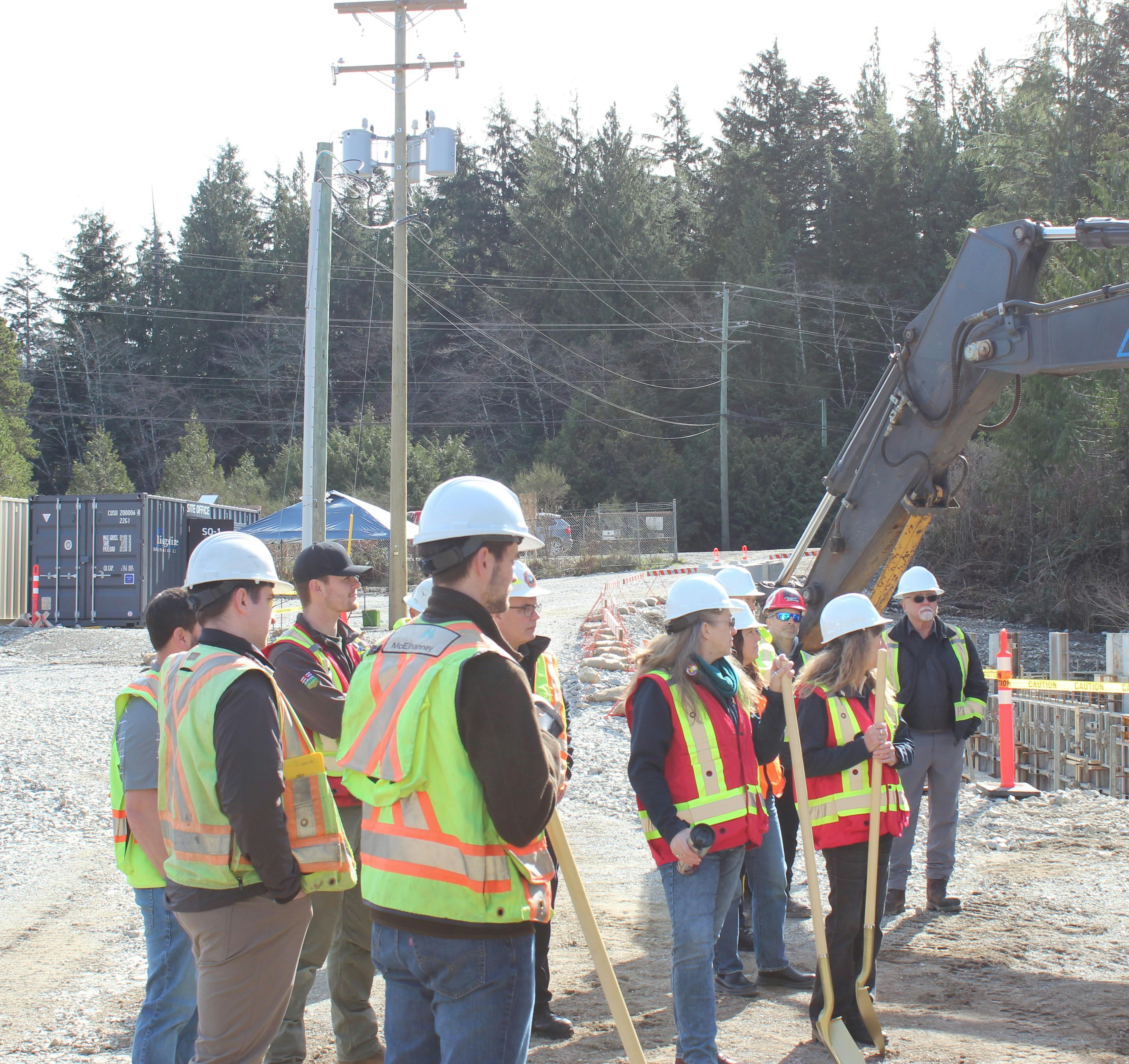 DoU Staff and contracting crew look on as project lead describes site area.