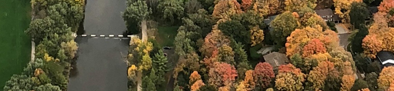 Aerial image of a tree covered neighbourhood along a river