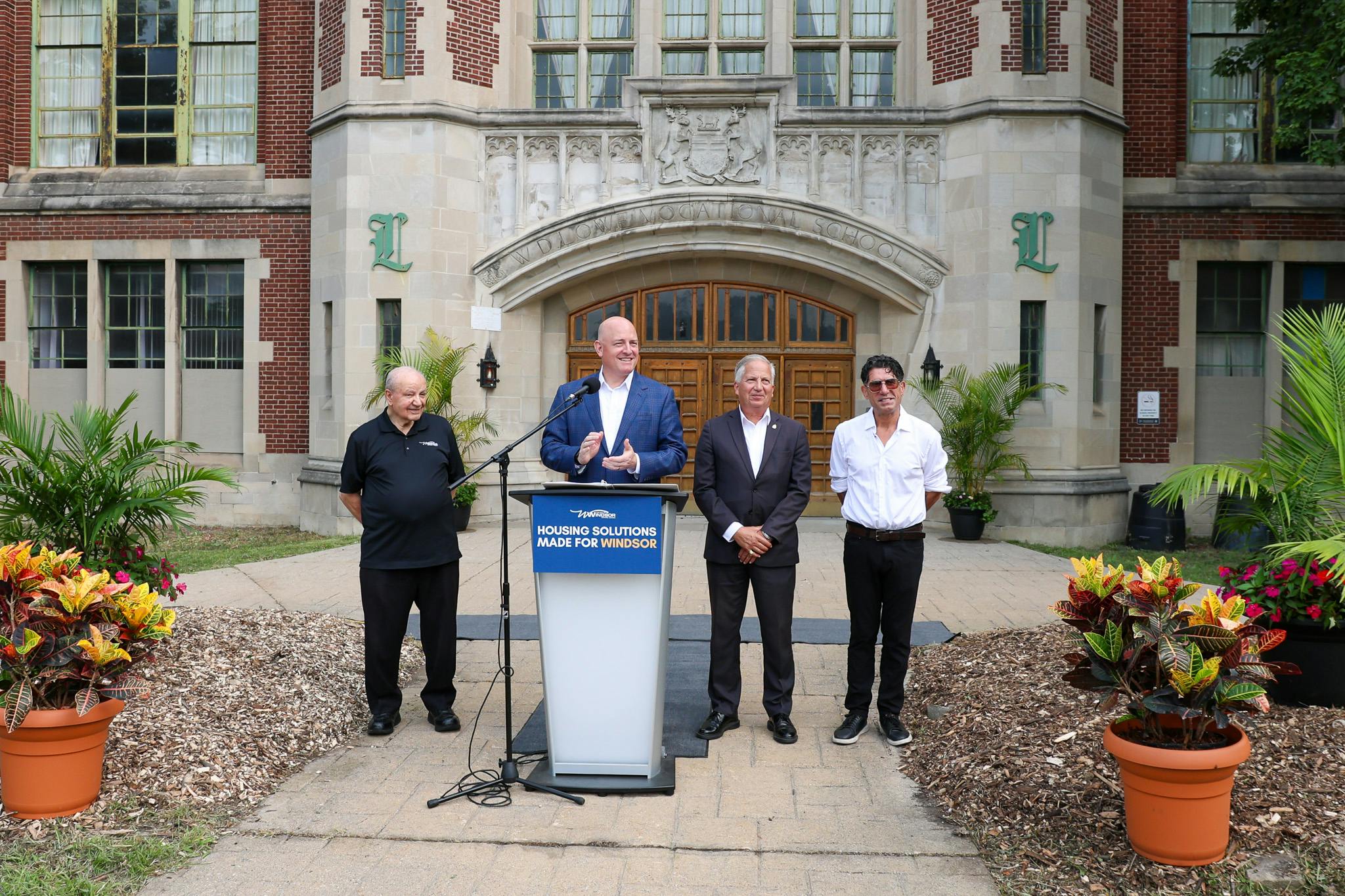Mayor Drew Dilkens with City Councillors at the podium in front of the former W.D. Lowe Secondary School