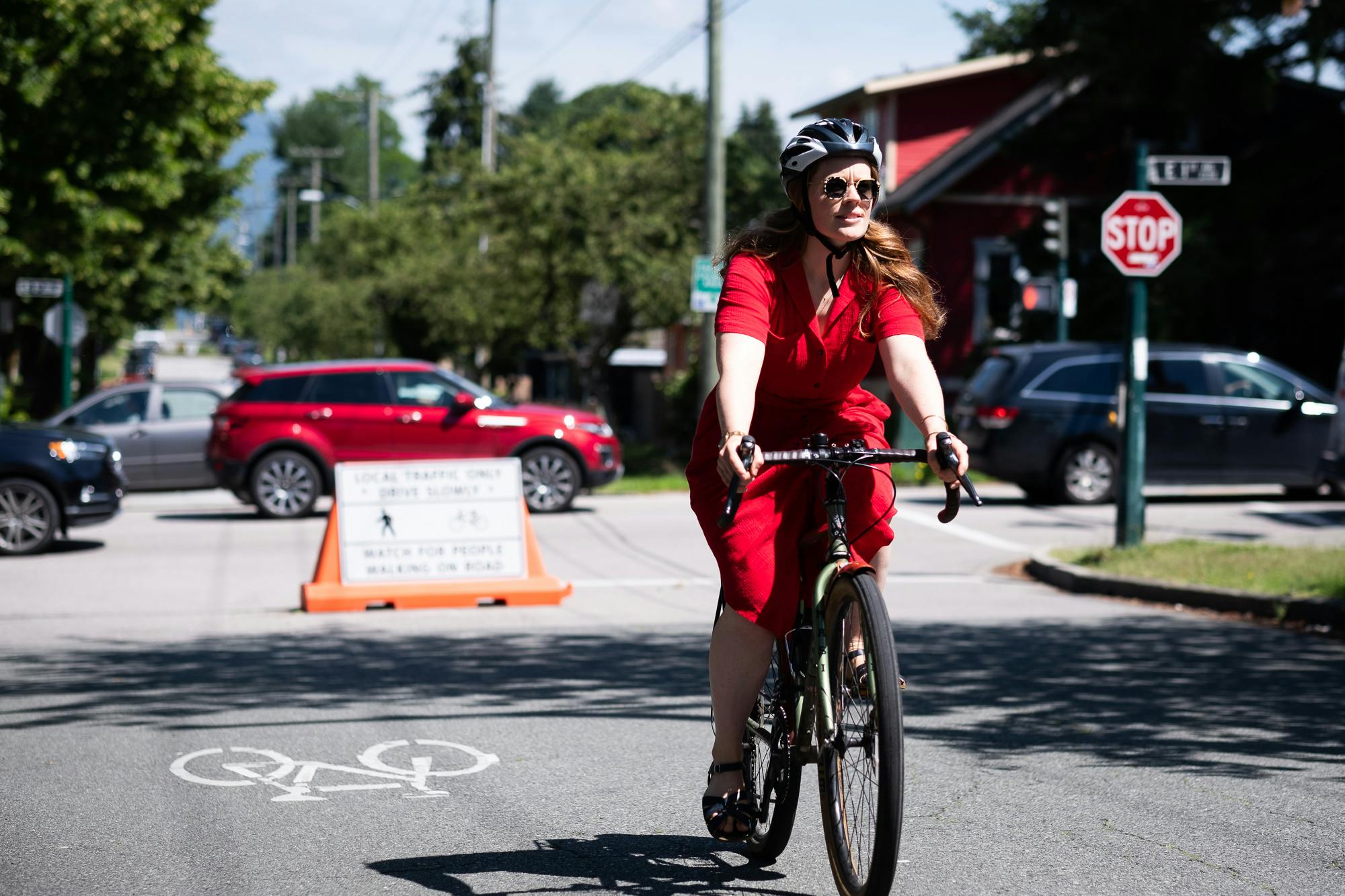 A cyclist in a red dress comfortably cycling along Slow Streets - Lakewood Drive.