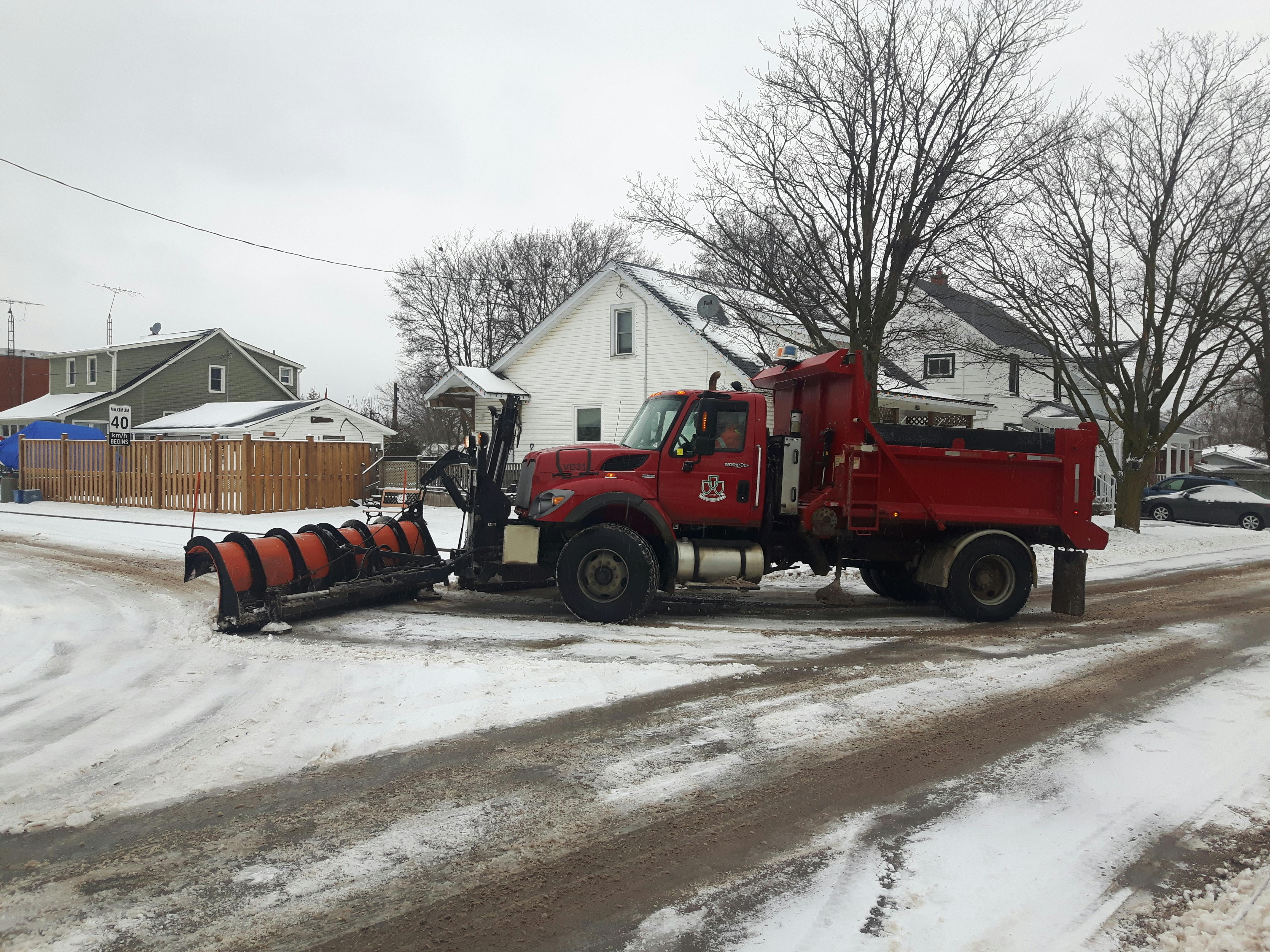 Snow plow clears snow in residential neighbourhood