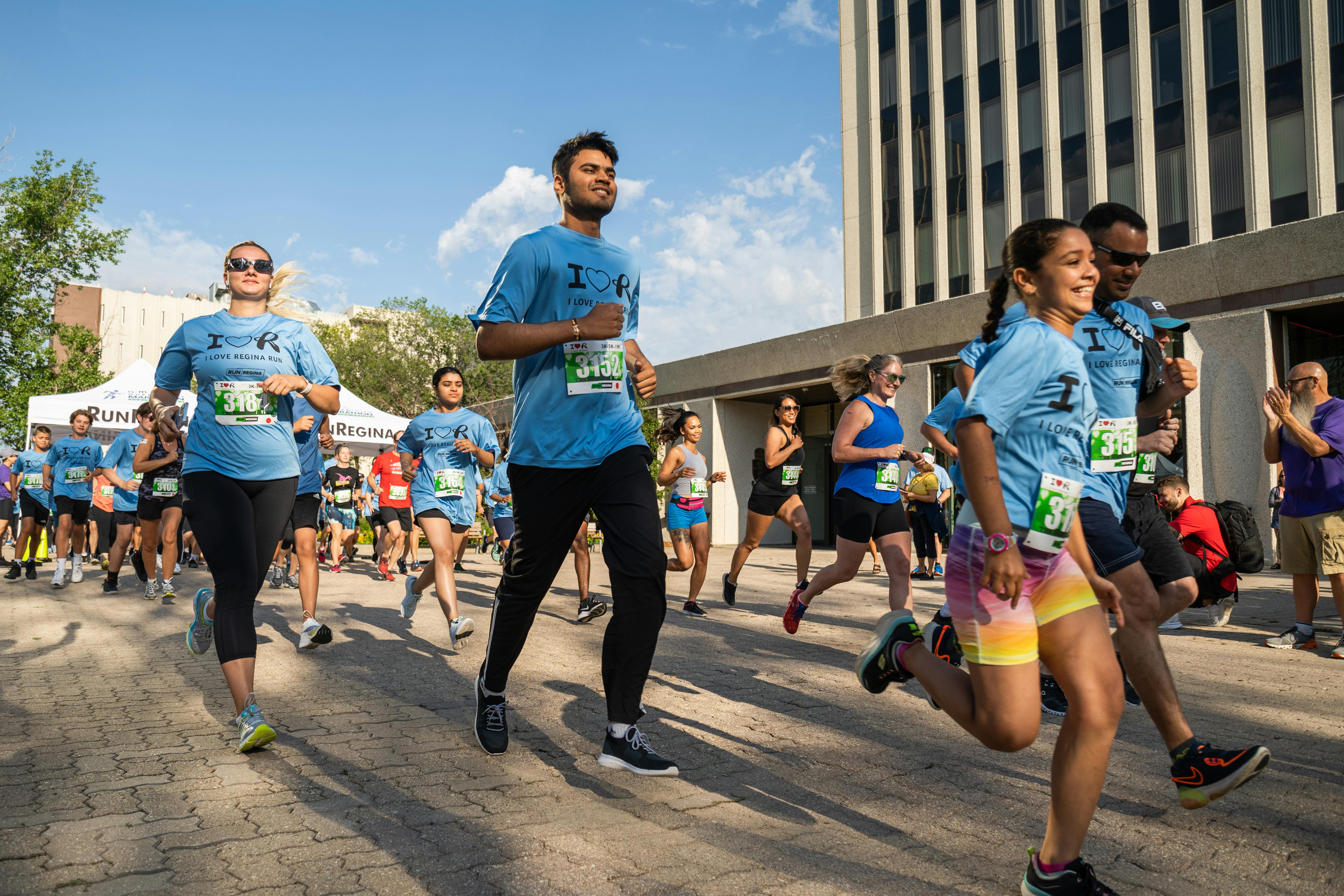 Smiling runners take part in the I Love Regina Day Run in front of City Hall.