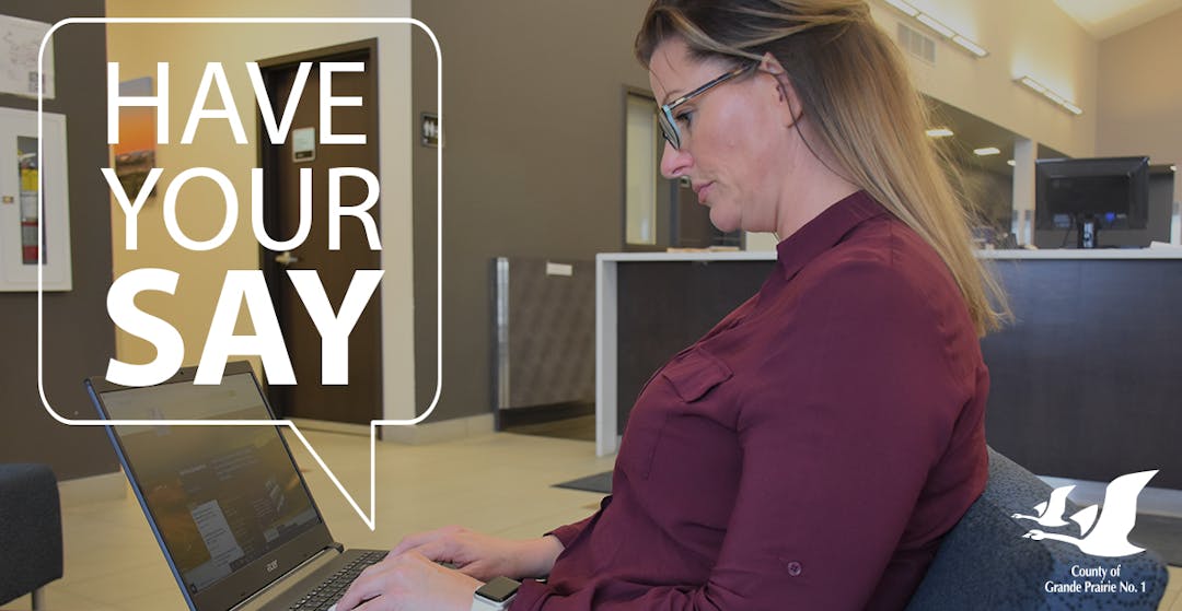 A woman using a laptop to participate online in the County of Grande Prairie's new website project. 