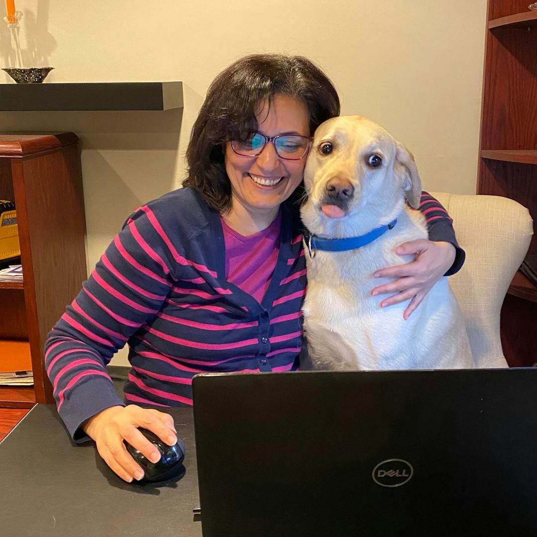 A lady working with her dog sharing the seat