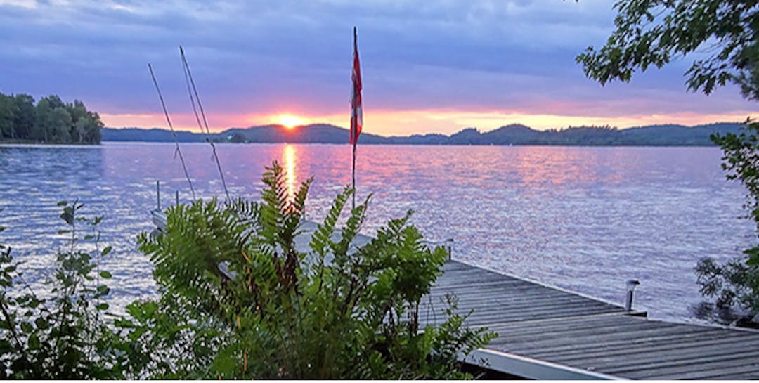 image of a dock on the water at sunset