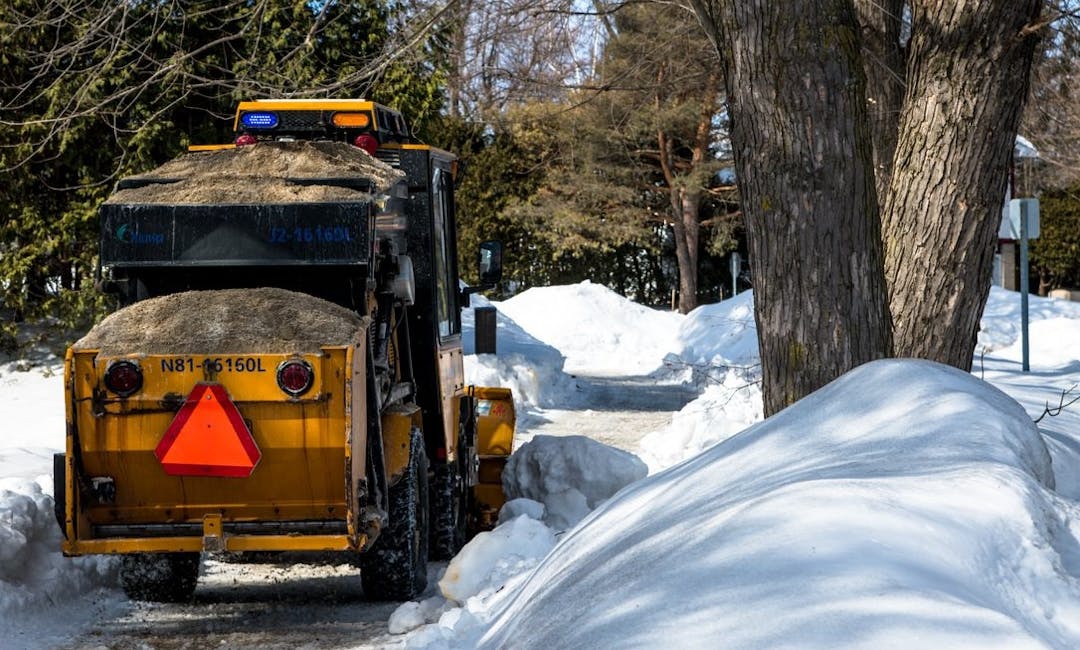 Plow clearing a snowy sidewalk