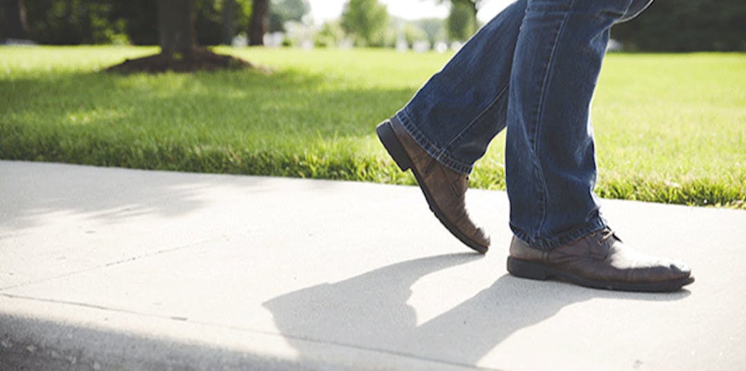 closeup of a sidewalk and shoes walking on it