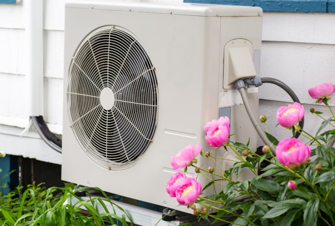heat pump fan next to outdoor wall of home