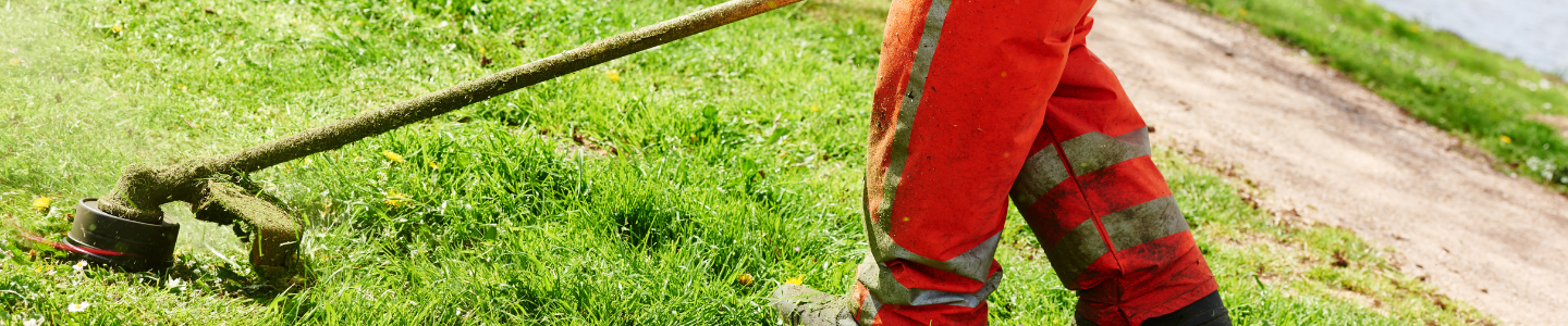 Close up of a worker using a grass trimmer