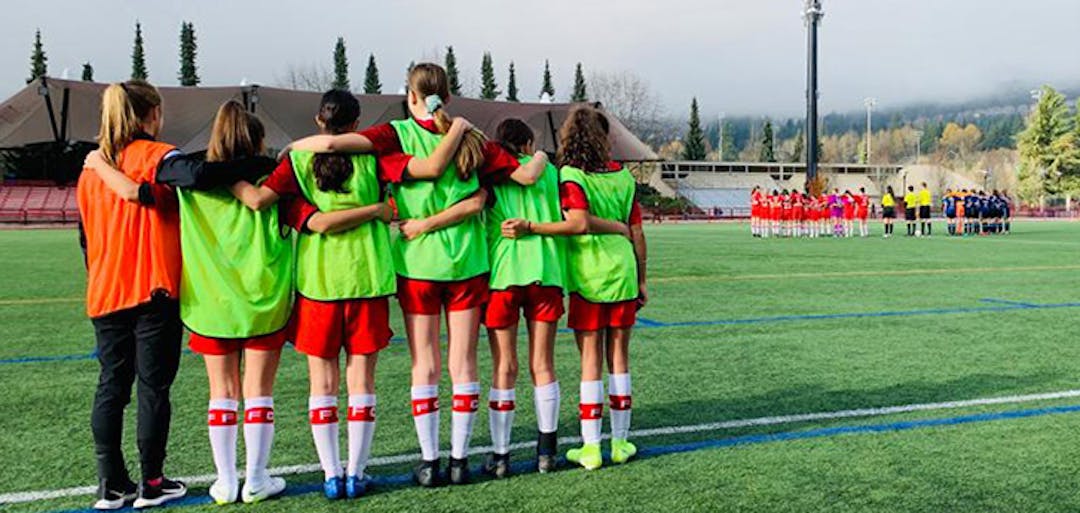 Team members linking arms at the edge of a sport field