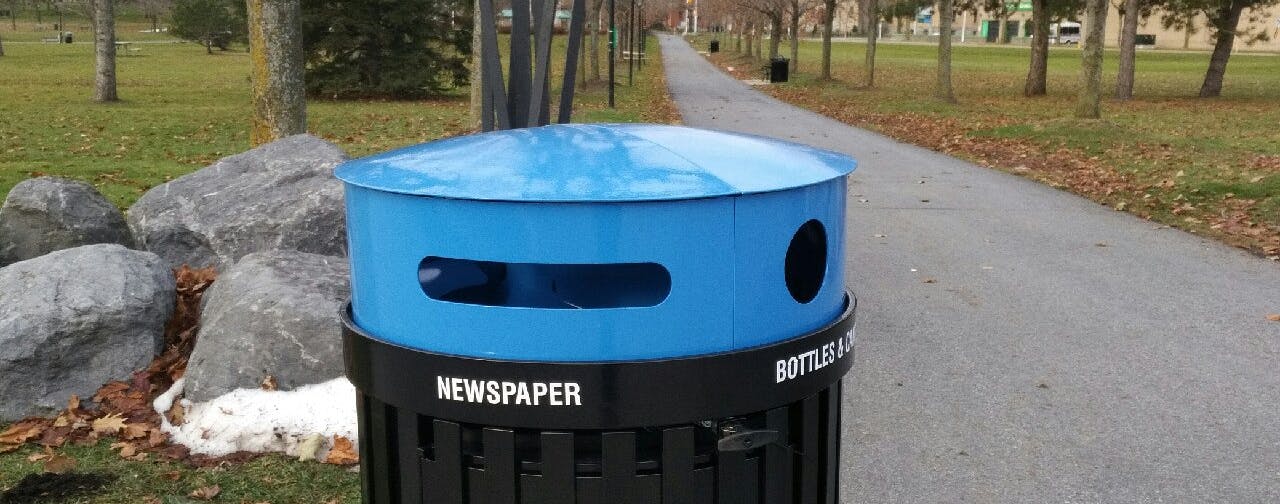 blue recycling bin top with black base and word "newspaper" written on the side