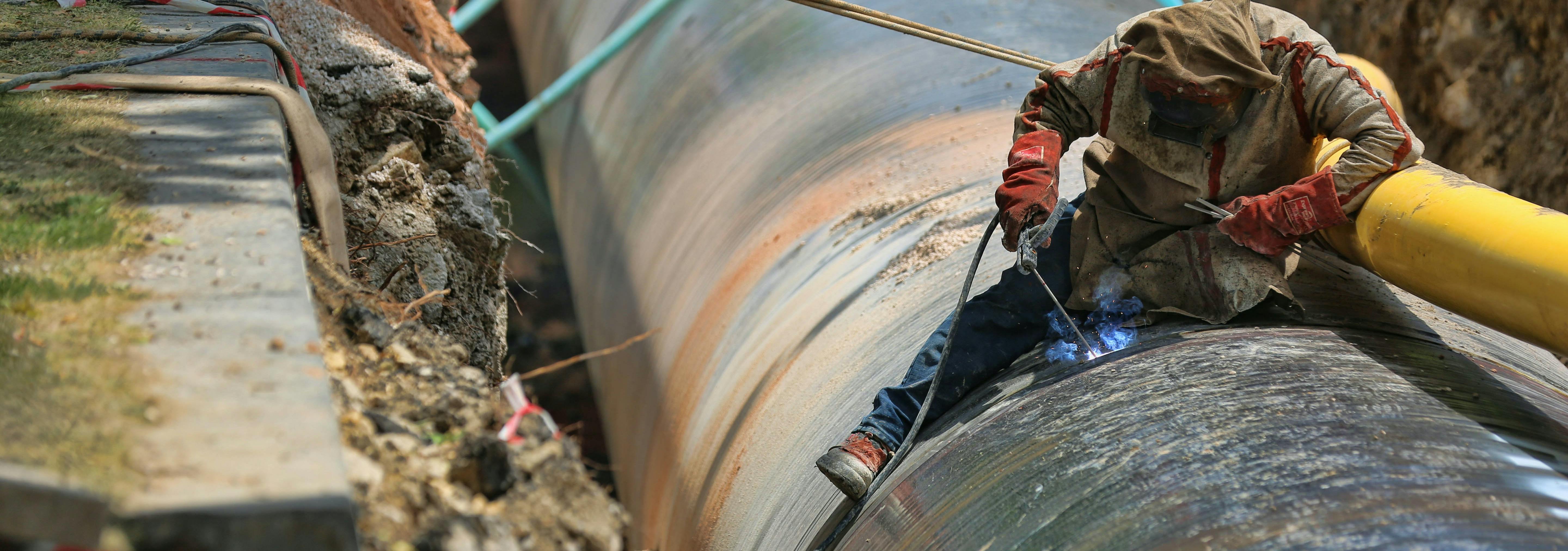 image of worker working on an underground pipeline
