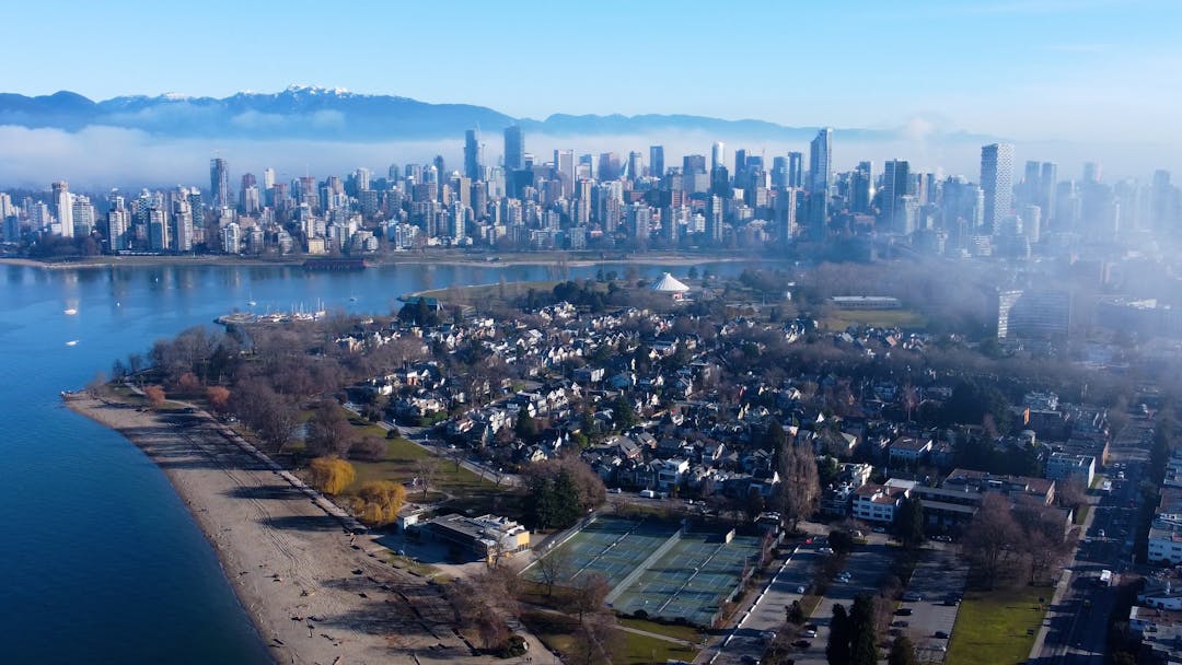 Aerial view of Kitsilano Beach Park with downtown and mountains in the background