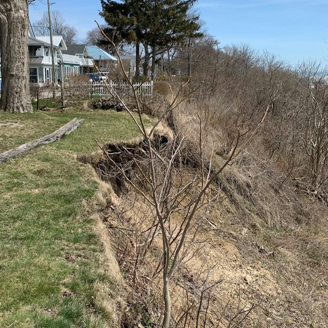 Front Street is a residential road located on the north side of the former Lake Erie bluff slope in Port Stanley.  The Lake Erie bluff slope is currently experiencing erosion and movements which are encroaching towards Front Street.  Steel gravity bin-type retaining walls were installed in the 1970’s and 80’s near the top of the slope along several sections of Front Street to stabilize sections of the top of slope and to protect the street.  These gravity bin-walls have performed successfully over several decades.  Rehabilitation of the unprotected areas experiencing movements at the top of the slope, which may compromise the municipal road (Front Street), are to be addressed.

The Municipality of Central Elgin has retained Golder Associates Ltd. to complete a geotechnical exploration and testing program for the slope and existing gravity bin retaining walls.  In July 2018, the Final Report “Geotechnical Exploration – Front Street Slope Stability Review, Port Stanley, Municipality of Central Elgin, Ontario” was provided to the Municipality.  

In September 2019, the Municipality contracted with IBI Group Inc. to complete a Schedule B Environmental Assessment of the project and provide engineering design, cost estimate, contract documentation, and drawings for the project by September 2020.

The scope of the reconstruction project will include new gravity type bin retaining walls with subdrain, curb & gutter, asphalt road and granular structure renewal, new catch basins, new storm sewer, and drainage adjustments for the existing gravity type bin-walls.  Sanitary Sewers and watermains in the area do not require replacement.   

Local traffic accommodation, emergency service access, and other related services access (school bus, garbage pickup) is paramount and shall be thoroughly considered during the design for construction.
