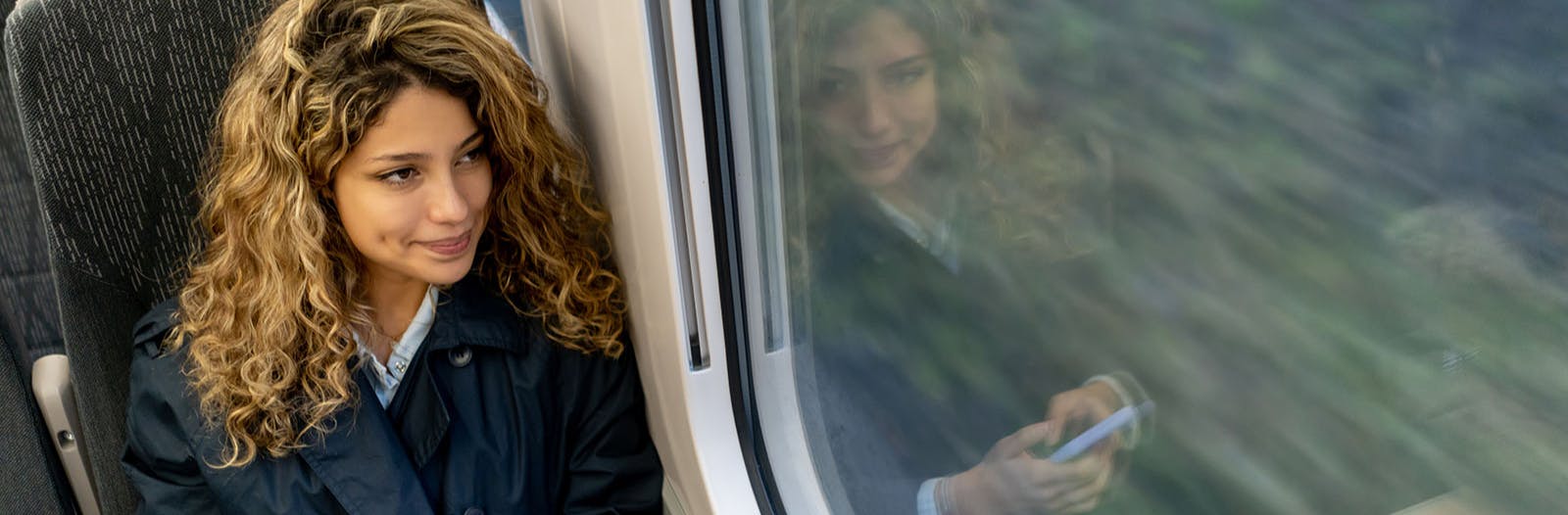 Woman looks out a train window