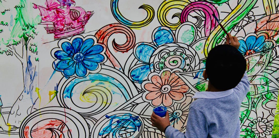 Boy painting flower mural