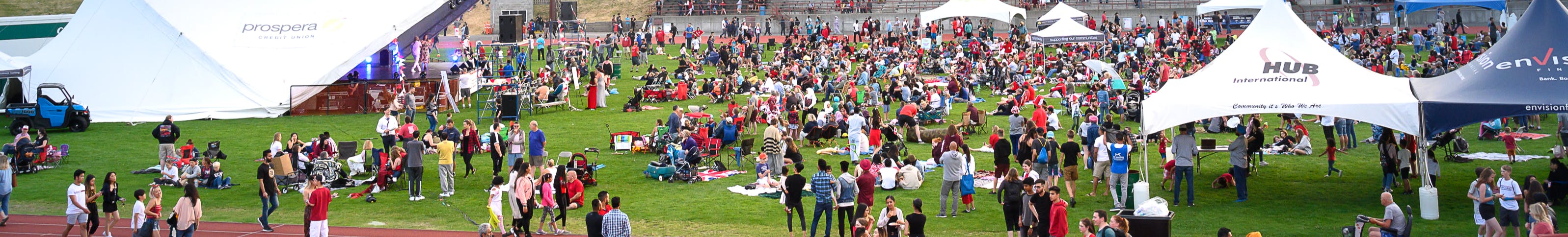 Image of Canada Day Event people on a field and tents