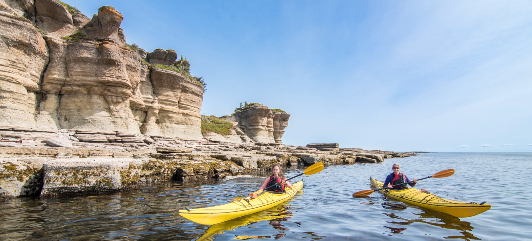 Two sea kayakers navigating the unique geology of Mingan Archipelago National Park Reserve