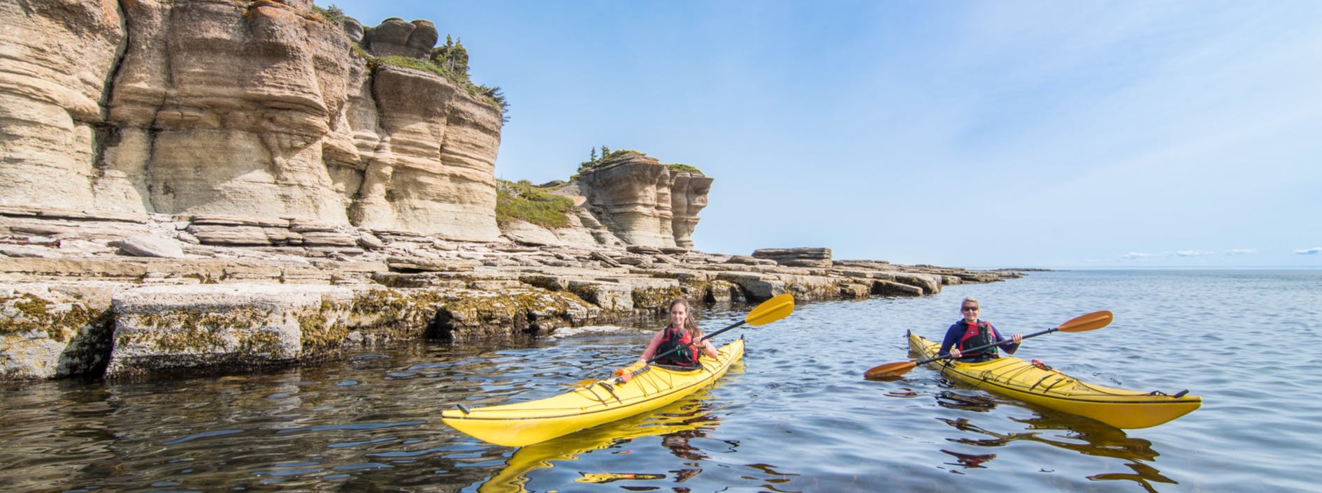 Deux kayakistes de mer naviguent parmi les éléments géologiques de la réserve de parc national de l’Archipel-de-Mingan