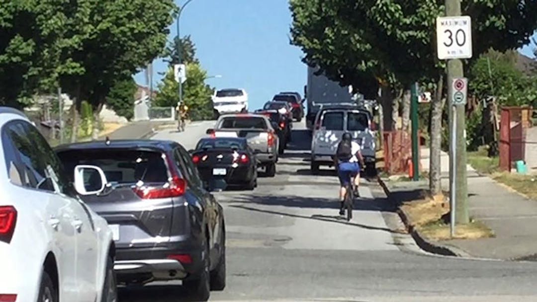 Photo of people driving and cycling along Adanac St 