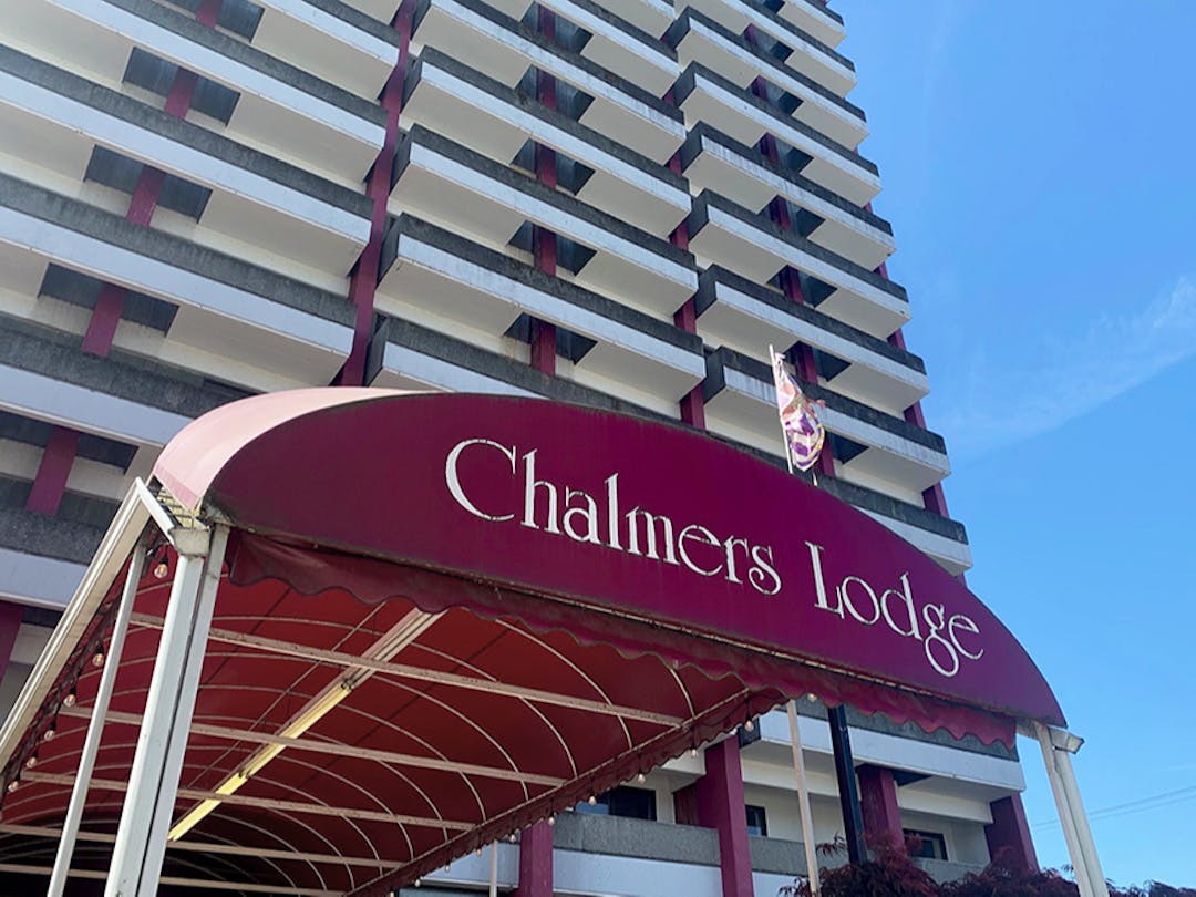 Front entrance of Chalmers Lodge. Showing a Magenta canopy leading up to a tall building with many balconies.