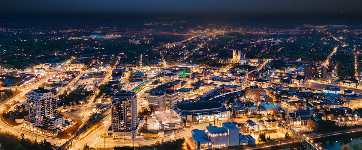 A long-exposure photo of Guelph at night, with the buildings and streets illuminated.