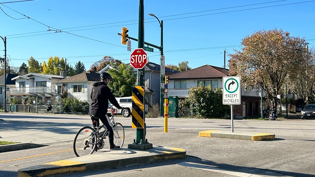 person on bicycle at a traffic calming diverter on Nanaimo and Adanac St. 